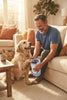 A man using the PawClean Pro electric paw washer on a dog's muddy paw in a cozy living room.